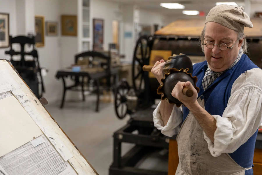 Gary Gregory inks a colonial-era printing press